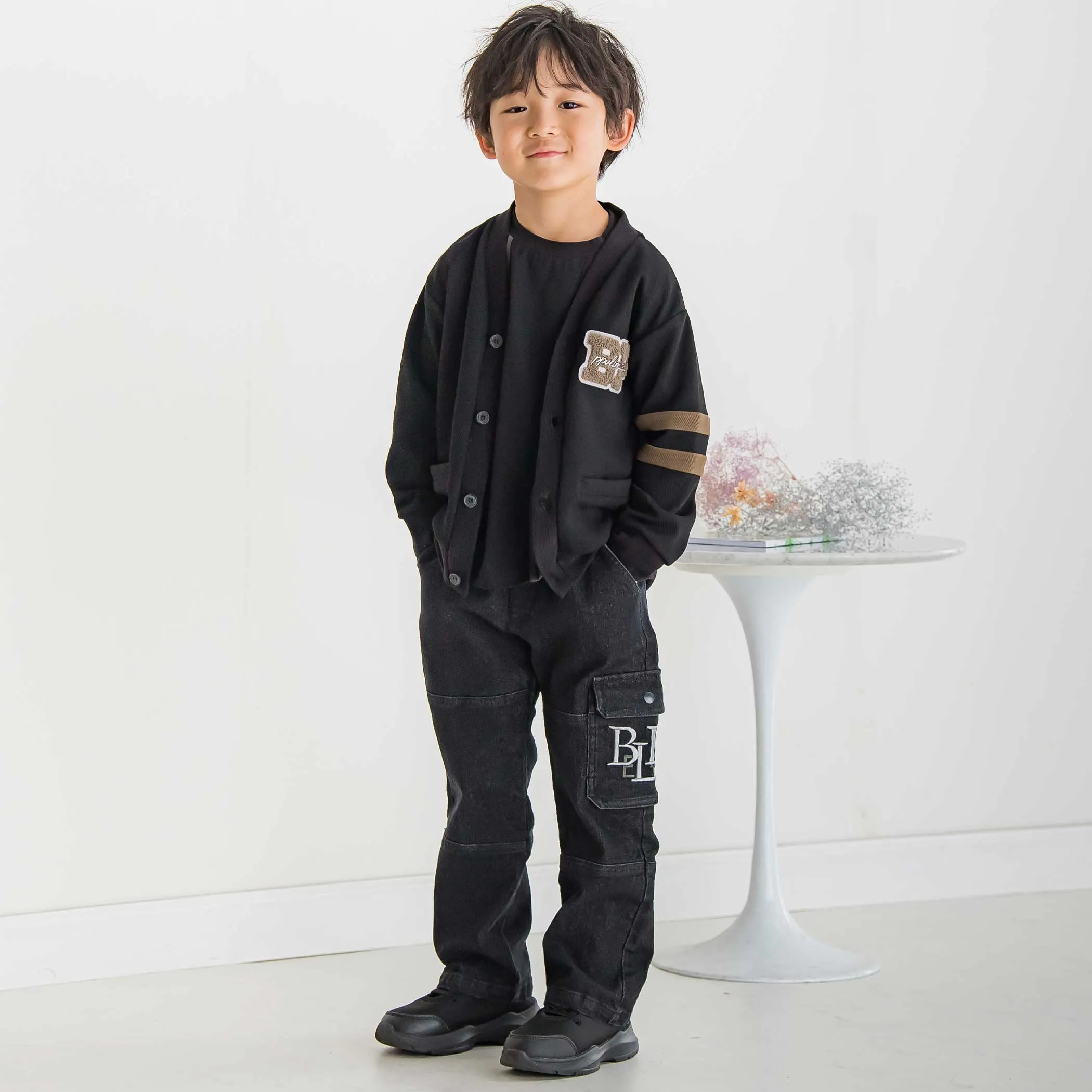 サガラワッペン黒カーディガンと黒カーゴパンツのプレッピー風コーデ